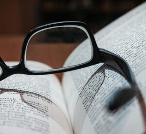 Eyeglasses resting on an open book, highlighting focus and depth of field.